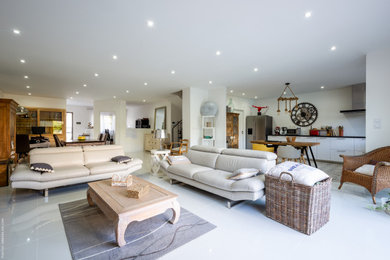 Großes, Offenes Modernes Wohnzimmer mit weißer Wandfarbe, Keramikboden, Eckkamin, Kaminumrandung aus Metall, freistehendem TV und beigem Boden in Bordeaux