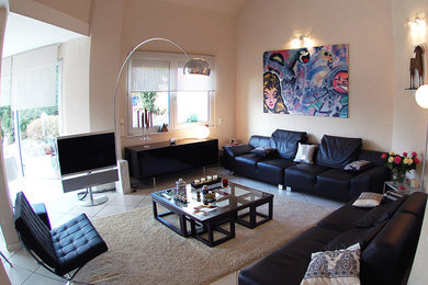 This is an example of a medium sized contemporary enclosed living room in Strasbourg with beige walls, ceramic flooring, a freestanding tv and white floors.