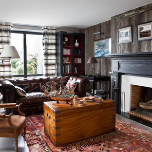 Foto de biblioteca en casa cerrada, costera, grande, sin televisor, con paredes marrones y chimenea tradicional