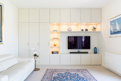 Cette image montre un grand salon design avec un mur blanc, un téléviseur fixé au mur et éclairage.