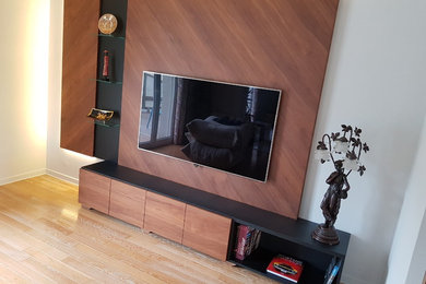 Inredning av ett modernt mellanstort allrum med öppen planlösning, med vita väggar, ljust trägolv och en väggmonterad TV