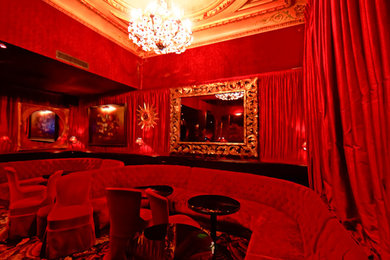 Exemple d'un salon chic de taille moyenne et fermé avec un bar de salon, un mur rouge, moquette, aucune cheminée, un téléviseur dissimulé et un sol noir.