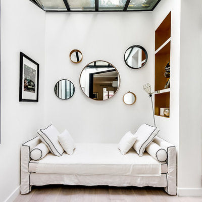 Inspiration for a mid-sized scandinavian open concept light wood floor living room library remodel in Paris with white walls, no fireplace and no tv