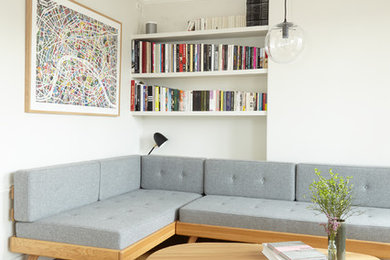 На фото: гостиная комната в стиле модернизм с белыми стенами, светлым паркетным полом и бежевым полом