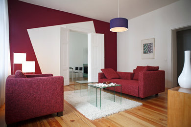 Idées déco pour un salon contemporain de taille moyenne et fermé avec une salle de réception, un mur rouge, un sol en bois brun et aucune cheminée.