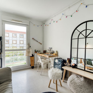 Cette image montre un salon bohème avec un mur blanc et un sol gris.