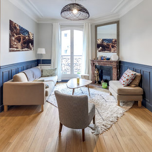 Inspiration pour un petit salon traditionnel ouvert avec un sol en bois clair, une cheminée d'angle, un manteau de cheminée en pierre, un mur gris, aucun téléviseur et un sol beige.