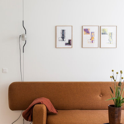 Example of a mid-sized danish open concept light wood floor and beige floor living room library design in Paris with white walls