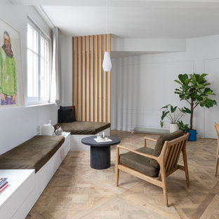 Aménagement d'un salon contemporain ouvert avec un mur blanc, un sol en bois brun, un sol marron et du lambris.