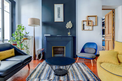 Réalisation d'un salon design de taille moyenne avec une salle de réception, un mur bleu, une cheminée standard et un sol orange.
