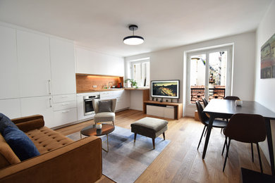 Inspiration pour un petit salon design fermé avec un mur blanc, un sol en bois brun, un téléviseur fixé au mur et un sol marron.
