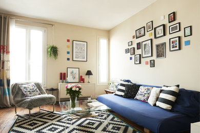 Foto de salón nórdico con paredes beige, suelo de madera en tonos medios y cortinas