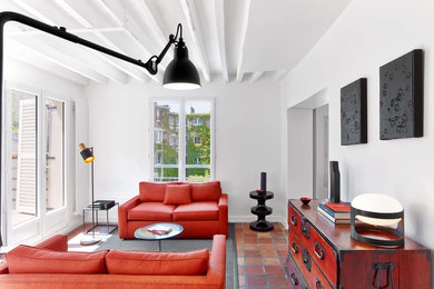 パリにある高級な中くらいなコンテンポラリースタイルのおしゃれなリビング (白い壁、テラコッタタイルの床、暖炉なし、テレビなし、赤いソファ) の写真