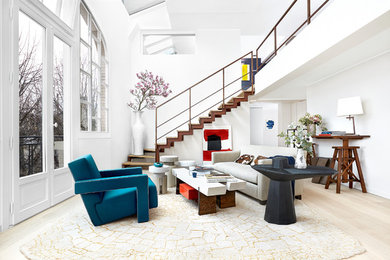 Inspiration pour un salon design ouvert avec un mur blanc, parquet clair, un sol beige et un escalier.