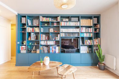 Imagen de biblioteca en casa abierta contemporánea de tamaño medio sin chimenea con paredes blancas, suelo de madera clara, televisor independiente y suelo beige