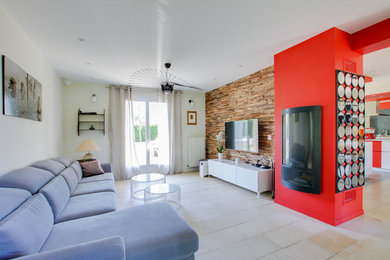 Пример оригинального дизайна: открытая гостиная комната среднего размера в современном стиле с разноцветными стенами, полом из керамической плитки, печью-буржуйкой, фасадом камина из бетона, телевизором на стене и бежевым полом