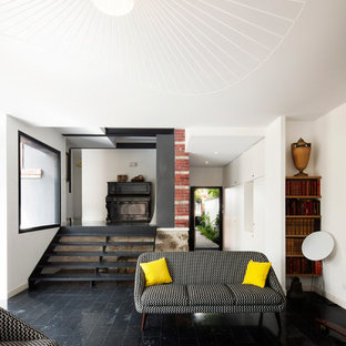 Cette image montre un salon design fermé et de taille moyenne avec un mur blanc, aucune cheminée, une salle de musique et aucun téléviseur.