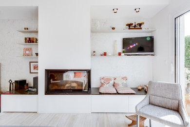 Idée de décoration pour un salon de taille moyenne et ouvert avec un mur blanc, parquet clair, une cheminée standard, un manteau de cheminée en plâtre, un téléviseur indépendant et un sol beige.