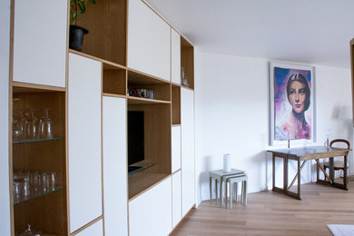 Cette photo montre un très grand salon moderne avec un mur blanc, parquet clair, aucune cheminée et un sol beige.