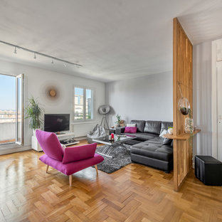 Exemple d'un salon tendance avec un mur gris, un sol en bois brun, un téléviseur indépendant et un sol marron.