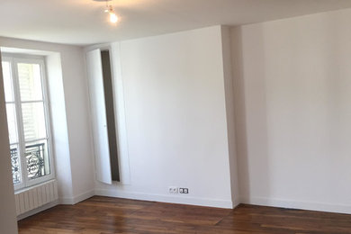 Mittelgroßes Klassisches Wohnzimmer ohne Kamin mit weißer Wandfarbe, braunem Holzboden, freistehendem TV und braunem Boden in Sonstige