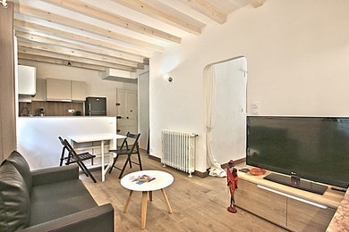 Cette photo montre un salon tendance ouvert avec un mur blanc, un sol en bois brun, une cheminée standard, un manteau de cheminée en plâtre et un téléviseur indépendant.