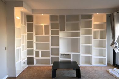 Inspiration pour un salon minimaliste avec un mur beige, parquet clair et un téléviseur dissimulé.