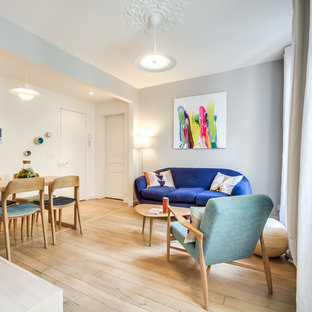 Inspiration pour un petit salon design ouvert avec un mur gris, un sol en bois clair et aucun téléviseur.