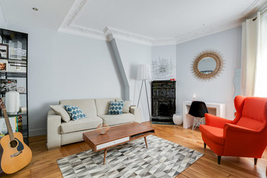 Imagen de salón abierto actual de tamaño medio con paredes azules, chimenea de esquina, suelo de madera en tonos medios y suelo marrón