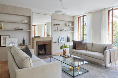 Exemple d'un salon tendance avec parquet clair, une cheminée standard, une salle de réception, aucun téléviseur, un mur beige, un manteau de cheminée en brique et un sol blanc.