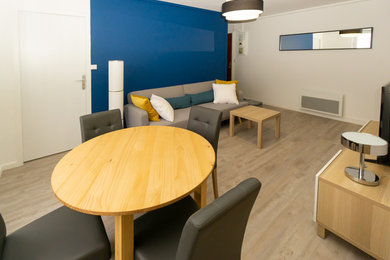 Cette image montre un salon design de taille moyenne et ouvert avec un mur bleu, un sol en vinyl et un téléviseur indépendant.