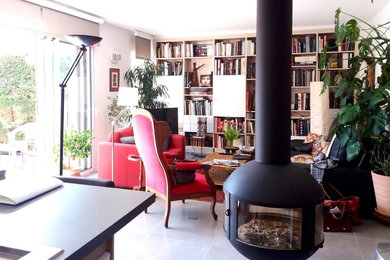 Cette photo montre un salon éclectique avec une bibliothèque ou un coin lecture, un mur blanc, un sol en carrelage de céramique, un poêle à bois, un téléviseur indépendant et un sol gris.