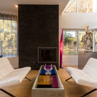 Cette photo montre un salon tendance avec un mur blanc, un sol en bois clair et un sol beige.