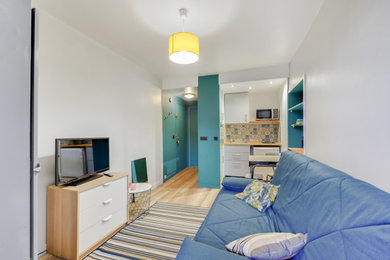 リヨンにある低価格の小さなエクレクティックスタイルのおしゃれなLDK (グレーの壁、ラミネートの床、暖炉なし、据え置き型テレビ、茶色い床) の写真