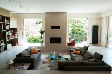 Cette image montre un grand salon design ouvert avec un mur blanc, une cheminée ribbon, un manteau de cheminée en métal, un téléviseur encastré et un sol beige.