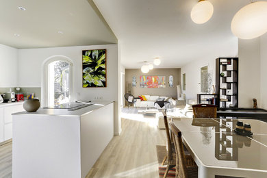 Cette image montre un grand salon design ouvert avec un mur beige, parquet clair et un sol beige.