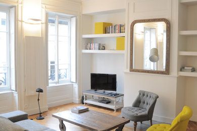 Inspiration pour un salon design ouvert et de taille moyenne avec un téléviseur indépendant, un mur blanc, un sol en bois brun, un sol marron et boiseries.
