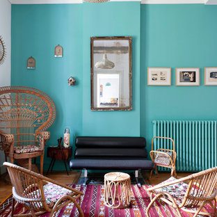Foto de salón para visitas cerrado, bohemio, de tamaño medio, sin chimenea y televisor, con paredes azules y suelo de madera en tonos medios