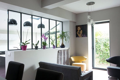 Exemple d'un grand salon moderne ouvert avec un mur gris et sol en béton ciré.