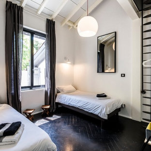 Inspiration pour un salon design avec un mur blanc, un sol en bois peint et un sol noir.