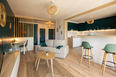 Inspiration pour un salon minimaliste de taille moyenne et ouvert avec un mur vert, parquet clair et un sol beige.