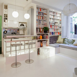 Idées déco pour un salon avec une bibliothèque ou un coin lecture contemporain ouvert avec un mur blanc et un sol blanc.