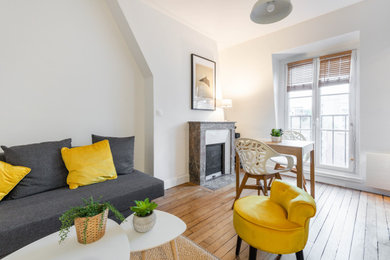 Aménagement d'un salon contemporain de taille moyenne et fermé avec un mur blanc, parquet clair, une cheminée standard, un manteau de cheminée en pierre, un téléviseur indépendant et un sol beige.