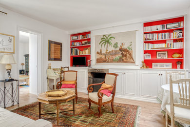 Свежая идея для дизайна: гостиная комната среднего размера в стиле фьюжн с с книжными шкафами и полками, белыми стенами, светлым паркетным полом, стандартным камином, фасадом камина из кирпича и коричневым полом - отличное фото интерьера