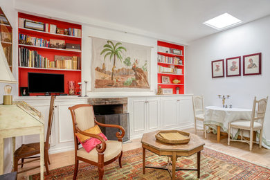 Aménagement d'un salon éclectique de taille moyenne avec une bibliothèque ou un coin lecture, un mur blanc, parquet clair, une cheminée standard, un manteau de cheminée en brique et un sol marron.