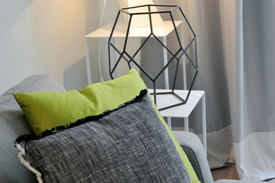Immagine di un soggiorno design con pareti grigie e parquet chiaro