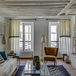 Idées déco pour un petit salon bord de mer fermé avec un mur blanc, un sol en bois brun, aucune cheminée, aucun téléviseur et un sol marron.
