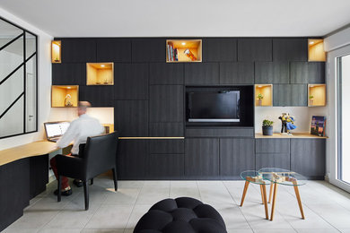 Cette image montre un salon design avec un mur noir, un sol en carrelage de céramique, un téléviseur encastré et un sol beige.