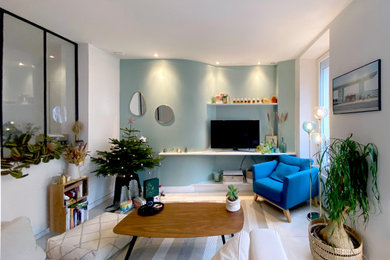 Idées déco pour un grand salon classique ouvert avec un mur bleu, un sol en calcaire, un téléviseur encastré et un sol beige.