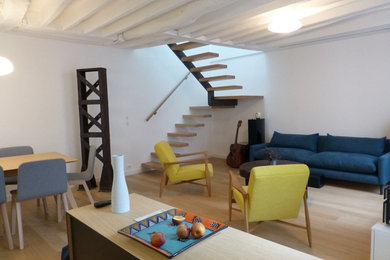 Großes, Offenes Modernes Wohnzimmer mit weißer Wandfarbe, hellem Holzboden und verstecktem TV in Paris